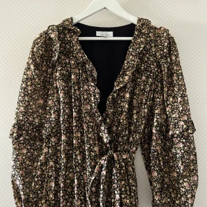 Klänning  - Blommig klänning från & other stories i storlek 38. Omlottklänning med knyte i midjan.