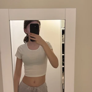 Vit croppad topp med knyt - Säljer en vit croppad topp med korta ärmar och knytning i ryggen. En väldigt fin och söt tröja som är enkel att styla. Storlek XS och endast provad och sen aldrig använd. Från HM