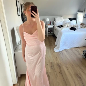 Ljusrosa balklänning - Elegant ljusrosa långklänning med smala axelband och draperad överdel. Perfekt för till exempel balen eller andra fina tillfällen. Aldrig använd. Säljer pga att det var lite för stor för mig upptill.💗