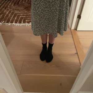 Två kjolar med blommor på. - Säljer två kjolar.Den lila är från Lindex och är i strl 170.Den är använd en gång.Den andra är i strl xs/xxs.