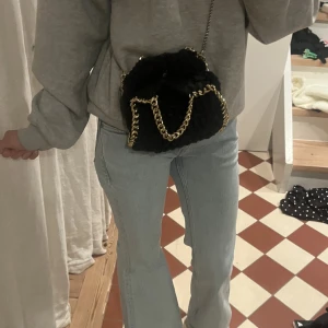 Svart pälsväska med guldkedja - Säljer en snygg svart stickad väska med en elegant guldkedja. 💕💕