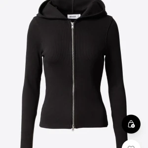 Svart ribbad hoodie från Weekday - Snygg svart ribbad hoodie från Weekday med dragkedja framtill. Perfekt för en stilren och bekväm look. Den har långa ärmar och en huva som ger en avslappnad känsla.