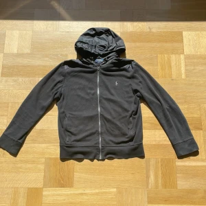 Ralph Lauren cardigan  - En snygg cardigan perfekt för sommaren/våren från Ralph lauren. Dragkedjan är tyvärr sönder se bild 4 men funkar bra ändå. Model är 180 och väger runt 65. Skriv om ni har frågor eller funderingar. Mvh Axel😆😆