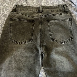 Grå jeansbyxor - Snygga grå jeansbyxor med en klassisk femficksdesign. Byxorna har en dragkedja och knapp framtill.