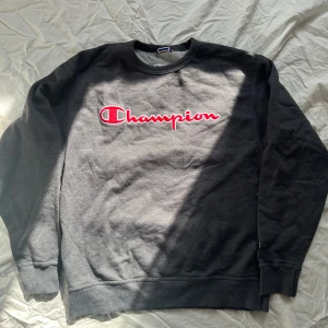 Grå sweatshirt från Champion - Säljer en klassisk grå sweatshirt från Champion med deras ikoniska logga i rött och vitt på bröstet. 