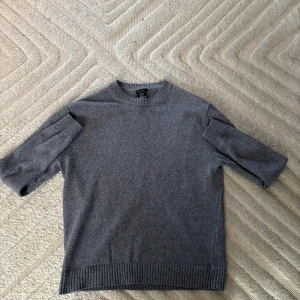 Grå tröja från Massimo Dutti - Säljer en stilren grå tröja från Massimo Dutti i 100% bomull. Tröjan har en klassisk rund hals och ribbade detaljer vid ärmslut och nederkant. Perfekt för en avslappnad och snygg look. Nypris 1900:-