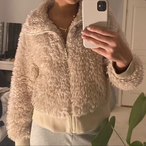 Beige teddyjacka från Zara - Mysig beige teddyjacka från Zara med dragkedja framtill. Jackan har långa ärmar och ribbade muddar vid ärmslut och nederkant. Perfekt för kyliga dagar! Storlek L men sitter som en S skulle jag säga🩵