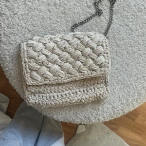 Beige/vit  stickad axelväska - Säljer en snygg beige stickad axelväska med en kedja till💓