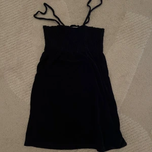 Svart/marinblå klänning från Juicy Couture - Snygg svart klänning från Juicy Couture i storlek XS. Klänningen har smala axelband och en smockad överdel 