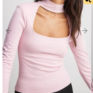 Rosa långärmad topp med unik halsdesign - Snygg rosa långärmad topp med en unik halsdesign som ger en modern touch. Perfekt för att sticka ut i mängden. Tillverkad i ett mjukt och bekvämt material.