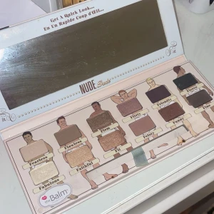 Nude Dude ögonskuggspalett från theBalm - En ögonskuggspalett med 12 olika nyanser i både matta och skimrande toner. Färgerna sträcker sig från ljusa beige och guld till mörkbruna och svarta nyanser. Paletten har en stor spegel och varje skugga har ett unikt namn.💞