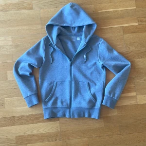 Grå hoodie med dragkedja från Ralph Lauren - Säljer en grå hoodie från Ralph Lauren med dragkedja framtill och två fickor. Tröjan har huva med snören och en liten broderad logga på bröstet. Nästan aldrig använt. Ny pris ligger på 2300kr. Pris kan diskuteras vid snabb affär.