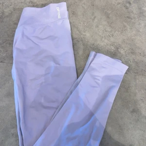 Ljuslila tights från Dfyne - Säljer ett par ljuslila tights från Dfyne. Perfekta för träning eller en avslappnad stil. Mjukt och stretchigt material som sitter skönt på kroppen. Använd en gång, Storlek L men passar M