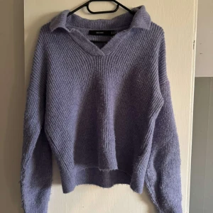 Ljuslila stickad tröja från Vero Moda - Mysig ljuslila stickad tröja från Vero Moda med krage och v-ringning.