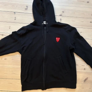 CDG zip-hoodie - CDG zip hoodie i bra skick. Storlek XL men skulle säga att den passsar L/M. Jag är 191 och väger 87kg och den sitter ganska litet på mig! Skynda er att fynda 