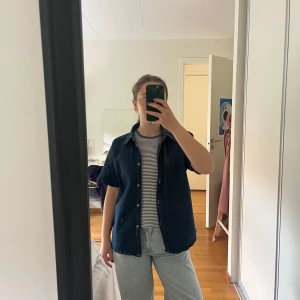 Mörkblå jeansskjorta med kort ärm - Säljer en mörkblå jeansskjorta med korta ärmar från only. 