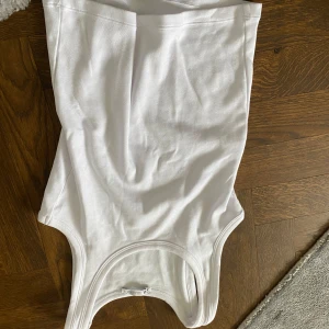 Vit linnetopp från ARKET - Säljer en klassisk vit linnetopp från ARKET. Toppen har rund halsringning och ärmlös design, perfekt att styla till olika outfits. Tillverkad i mjuk bomull för en bekväm känsla.