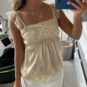 Söt topp - Så fin satintopp med knappar och spetsband🥰🥰 Storlek 38 men passar även S💕💕 Första bilden är lånad🌸🩷