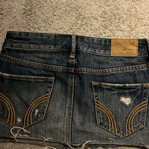 Mörkblå jeanskjol från hollister!  - Säljer ett par mörkblå jeansshorts från Hollister med slitna detaljer och fransig kant. Shortsen har klassiska fickor både fram och bak samt dekorativa sömmar på bakfickorna. Perfekta för sommaren! aldrig använd.  Skriv för frågor eller fler bilder! Priset kan diskuteras! 
