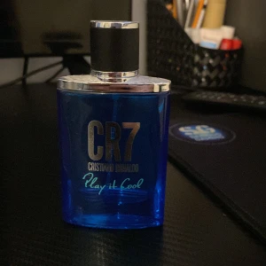 CR7 Play It Cool parfym - Fräsch parfym i blå glasflaska från Cristiano Ronaldo, CR7 Play It Cool. Flaskan har silverfärgat lock och detaljer, perfekt för dig som gillar sportiga och energiska dofter.