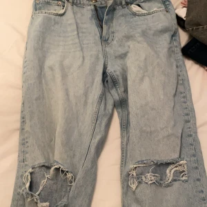 Ljusblå slitna jeans från Perfect Jeans - Ljusblå jeans med raka ben och slitna detaljer vid knäna från Perfect Jeans. Klassisk femficksmodell med normal passform och hög midja. Perfekta för en avslappnad och trendig look.