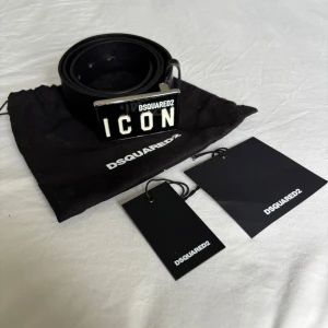 Svart skärp från Dsquared2 med ICON-spänne - Säljer ett svart bälte från Dsquared2 med ett stort metallspänne där det står 'ICON'. Köpt av mig, så kommer med originalpåse och tags samt kvitto. Nytt kostar det 2899.