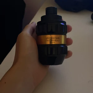 Spicebomb herrparfym från Viktor & Rolf - Säljer en Spicebomb herrparfym från Viktor & Rolf. Flaskan är svart med en guldfärgad etikett och har en unik, granatinspirerad form. Doften är kryddig och intensiv, perfekt för dig som gillar starka och maskulina parfymer. 75% kvar i den av 1000ml