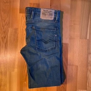 Blå Replay Anbass jeans - Säljer ett par blå Replay Anbass jeans med klassisk femficksdesign och snygga detaljer på bakfickan. Jeansen har normal passform och är tillverkade i ett mjukt denimtyg som ger en bekväm känsla. Perfekta för dig som gillar stilrena jeans med modern touch. Använda ett fåtal gånger men fortfarande väldigt bra skick!🔥