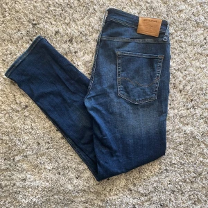 Blå jeans från Jack & Jones Regular Clark - Säljer ett par klassiska blå jeans från Jack & Jones, modell Regular Clark. Jeansen har normal passform ( 34/34)