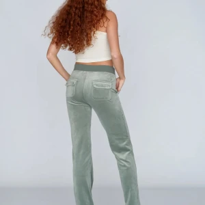 Gröna juicy byxor - Snygga ljusgröna mjukisbyxor med bred resår i midjan och dragsko. Byxorna har stora fickor både fram och bak, varav bakfickorna har knappar. De är uppsydda ner till eftersom att de var för långa men det är lätt att ta bort genom att bara stryka. 