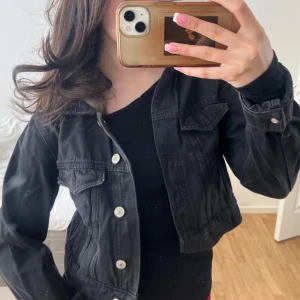 Jeansjacka - Svart croppad jeansjacka med silvriga knappar, snygg figurnära passform😚från pullandbear storlek S men passar XXS-S