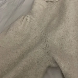 Vit stickad tröja från Vero Moda - Mysig vit stickad tröja från Vero Moda med rund halsringning och lätt puffade axlar. Tröjan har en enkel och stilren design som passar perfekt till lager-på-lager under kyliga dagar. Ribbstickad kant vid halsen ärmöpningen och nedre delen av tröjan för extra detalj. har använt flera gånger men är i ett fint skick. Orginal pris är 229kr men säljer endast för 99kr💕