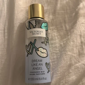 Victoria's Secret Dream Like An Angel - Parfymmist från Victoria's Secret, Dream Like An Angel. Flaskan är ljusblå med glittriga läppar, hjärtan och X-motiv samt har ett guldigt lock. Rymmer 250 ml och har en lekfull och trendig design som sticker ut i badrumshyllan.