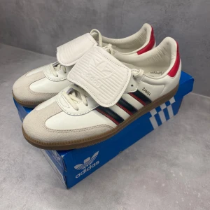 Adidas Samba skor vit/röd - Säljer ett par riktigt feta adidas samba i unik design, köpte på Zalando för cirka 1 månad sedan och är slutsålda. Helt nya, var tyvärr aningen för små för mig så säljer dem, hör av er för frågor!