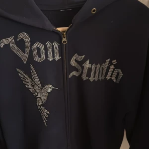 Von studio tröja - Svart hoodie från Von Studio med dragkedja och huva. I fint skick och har inga slitningar. Lappen är tyvärr borta men storleken är mellan M-L. Hör av er vid funderingar