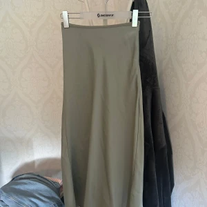 Ljusgrön långkjol från Amisu - Säljer en stilren ljusgrön långkjol från Amisu. Kjolen har en rak och enkel design utan mönster eller detaljer, vilket gör den lätt att matcha med olika toppar. 