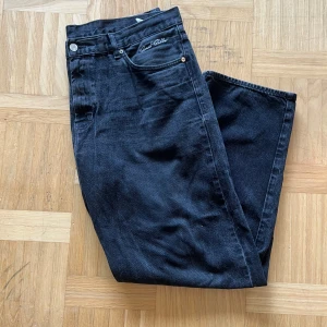Svarta jeans från Sweet SKTBS  - Snygga svarta jeans från Sweet Skbts med broderad logga vid fickan. Jeansen har raka ben, klassisk femficksdesign och är tillverkade i mjukt bomullsjeans. Perfekta för dig som gillar en clean och tidlös look. Köpte från Junkyard för ca 1 år sedan, använda sparsamt fåtal gånger. Mått längd(hela byxan): 108cm, Bredd ben 25cm, bredd midja 51cm, längd ben ca 75cm