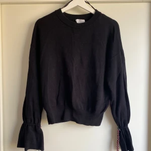 Svart långärmad tröja från &Otherstories - Skön och mjuk  svart långärmad tröja från &Otherstories med cool ”sportig” detalj i ärmen. 