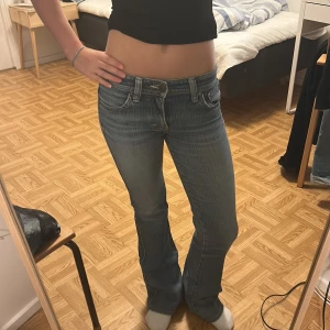 Venus Jeans bootcut lågmidjade blå - Säljer ett par klassiska blå Venus Jeans med låg midja och bootcut. Jeansen har snygga detaljer på bakfickorna och en ljus tvätt som ger en vintagekänsla. Perfekta för dig som gillar 00-talsstil och vill ha ett par jeans med riktigt skön passform. Skriv gärna privat om ni vill ha fler bilder eller har frågor. Har ej några defekter med säljer pga att de inte används☺️