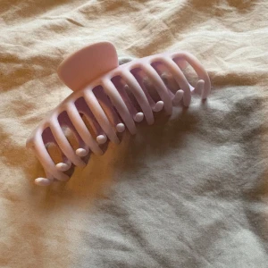 Ljuslila hårklämma i plast - Snygg ljuslila hårklämma med matt finish och breda, rundade tänder som håller håret på plats. Perfekt för att skapa en chill och effortless look. Klämman är tillverkad i plast och har en stark metallfjäder för extra grepp.