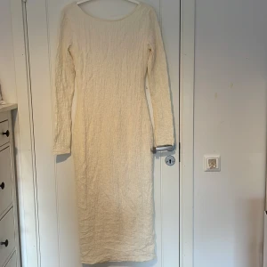 Långärmad ljus klänning från Nelly - Säljer en lång, ljusbeige klänning från Nelly i storlek XS. Klänningen har lång ärm, v-ringad rygg och en snygg slits framtill. Materialet är krinklat och känns mjukt mot huden, perfekt för dig som gillar stilrena och enkla plagg med en twist.