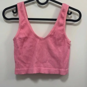 Rosa ribbad linnetopp från Forever 21 - Säljer en söt rosa ribbad linnetopp från Forever 21. Toppen har djup v-ringning och är ärmlös, perfekt för varma dagar eller som ett lager under en skjorta. Supermjuk och stretchig i materialet.