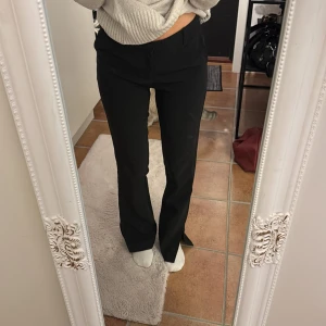 Svarta kostymbyxor med bootcut - Säljer ett par svarta kostymbyxor med bootcut. De har en slits också vid fötterna! Från märket neo noir storlek XS