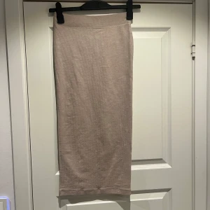 Beige långkjol från Gina Tricot - Säljer en beige långkjol från Gina Tricot. Kjolen har en rak passform och resår i midjan för extra komfort. Perfekt att styla med en enkel topp eller en oversized tröja.