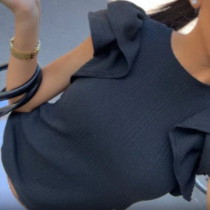 Svart ribbad tröja  med volangärmar - svart ribbad top  med snygga volangdetaljer