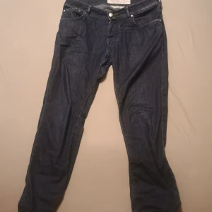 Mörkblå jeans från Jacob Cohën Style 622 - Säljer ett par mörkblå jeans från Jacob Cohën, modell Style 622. Klassisk femficksdesign med snygga gröna sömmar och exklusiv känsla. Perfekta för dig som gillar italiensk design och skräddad passform. Väldigt sköna jeans till sommar eller vår. STORLEK: W32 längd 100CM. Kolla på min Vinted profil esi0123 för mer information och bilder. Pris kan diskuteras, skicka bara ett prisförslag om du är intresserad.