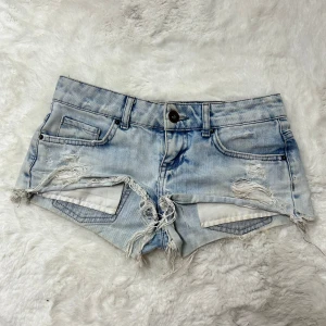 Lågmidjade jeansshorts med hål  / minishorts vintage  - Supersnygga ljusblåa lågmidjade jeansshorts. Står ingen storlek men upskattar de till en xs. Se mått. Midjemått:37. Köp sker via köp nu, jag postar inom 24h. Kvar tills markerad såld 