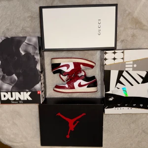 Nike Air Jordan 1 Low röd och vit  - Säljer ett par Nike Air Jordan 1 Low i rött, vitt och svart. Skorna har klassisk låg siluett, röd swoosh och snörning. Perforerad tå och broderad Air Jordan-logga på hälen. Perfekta för dig som gillar streetwear och  sneakers.