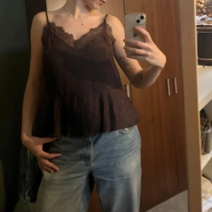 spetsdetaljerad linnetopp från H&M - Säljer en lila linnetopp från H&M. Toppen har fina spetsdetaljer längs urringningen och en lätt volang nertill. Fin till sommaren