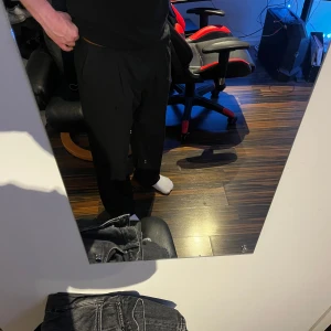 Svarta kostymbyxor från H&M - Säljer ett par svarta kostymbyxor från H&M med klassisk rak passform. Perfekta för en stilren look och passar till många olika outfits. Storlek (EUR) 54, skulle säga passar folk som har L/XL runt 180/190